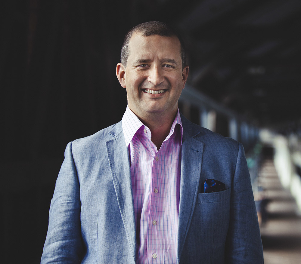 Jono Perry in a blue jacket and pink shirt.