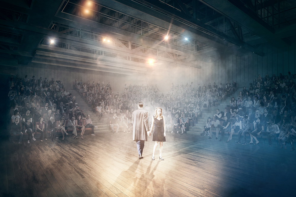 A render of two actors surrounded by audience.