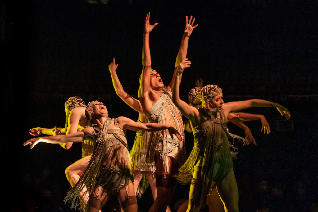 A group of actors from Cabaret dancing with arms outstretched.