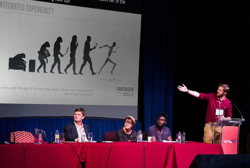 Ian points to a graphic of a chimpanzee watching TV evolving into a running robot.