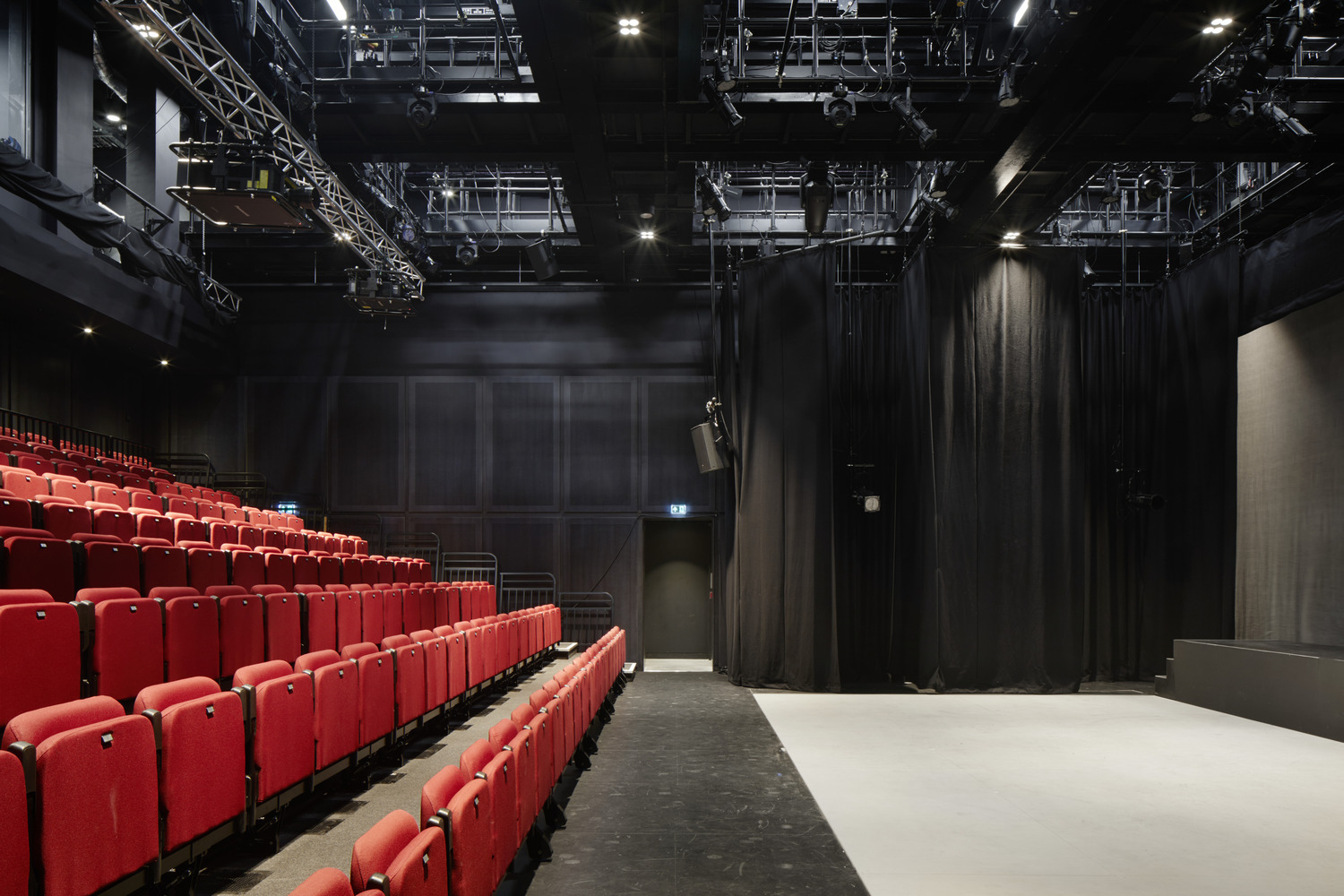 Red folded seating before an empty performance area.