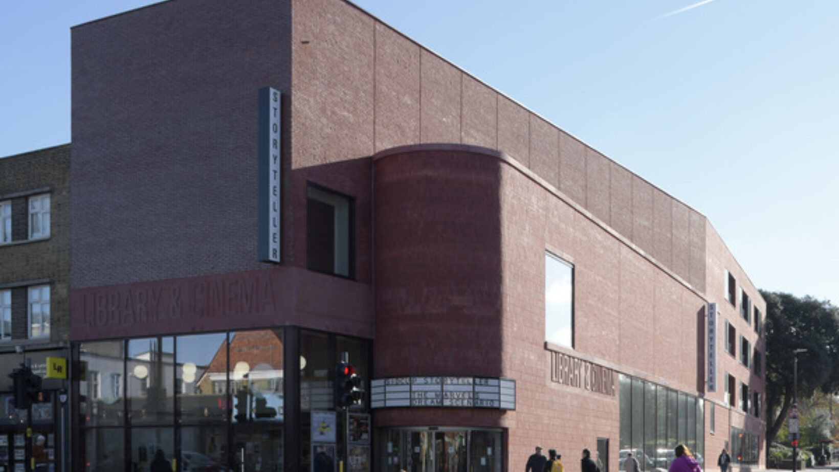 Exterior of brick building with Library & Cinema signage and Storyteller sign.