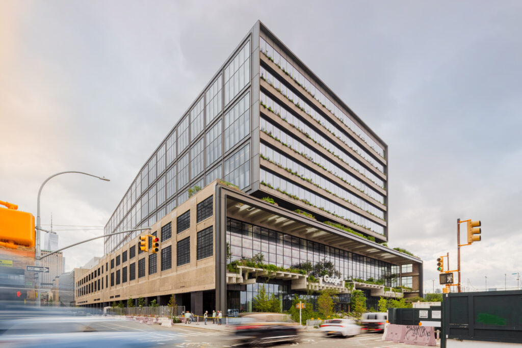 The rectangular terminal building seen from the street, with many layers of greenery growing along the exterior.