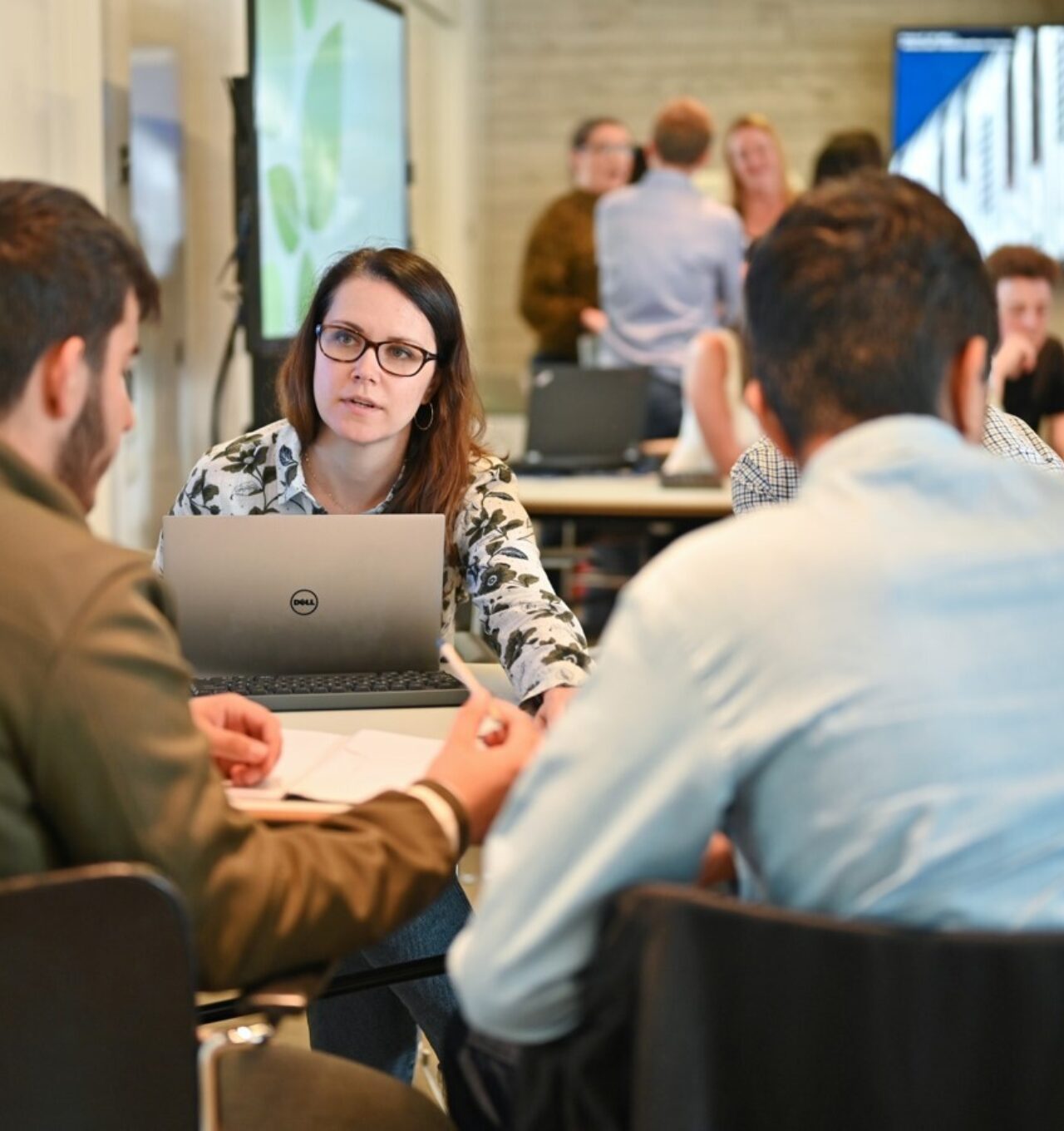 Team members in discussion around a laptop.