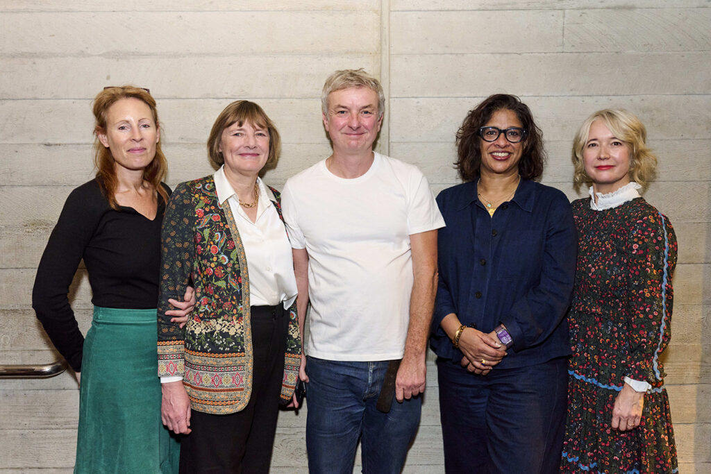 A group of five people post for a photo.