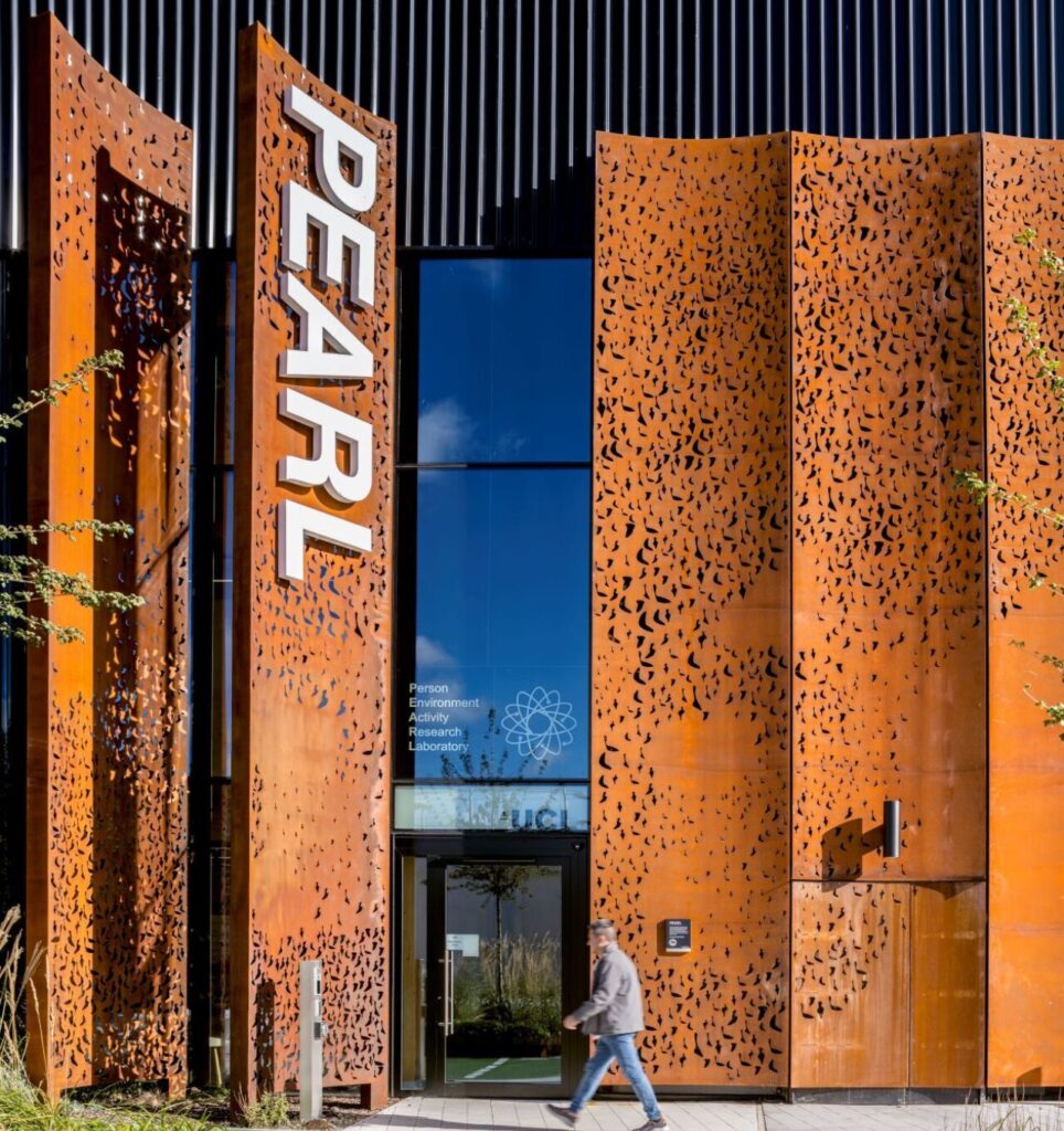 The exterior of a building with perforated orange steel facade and 