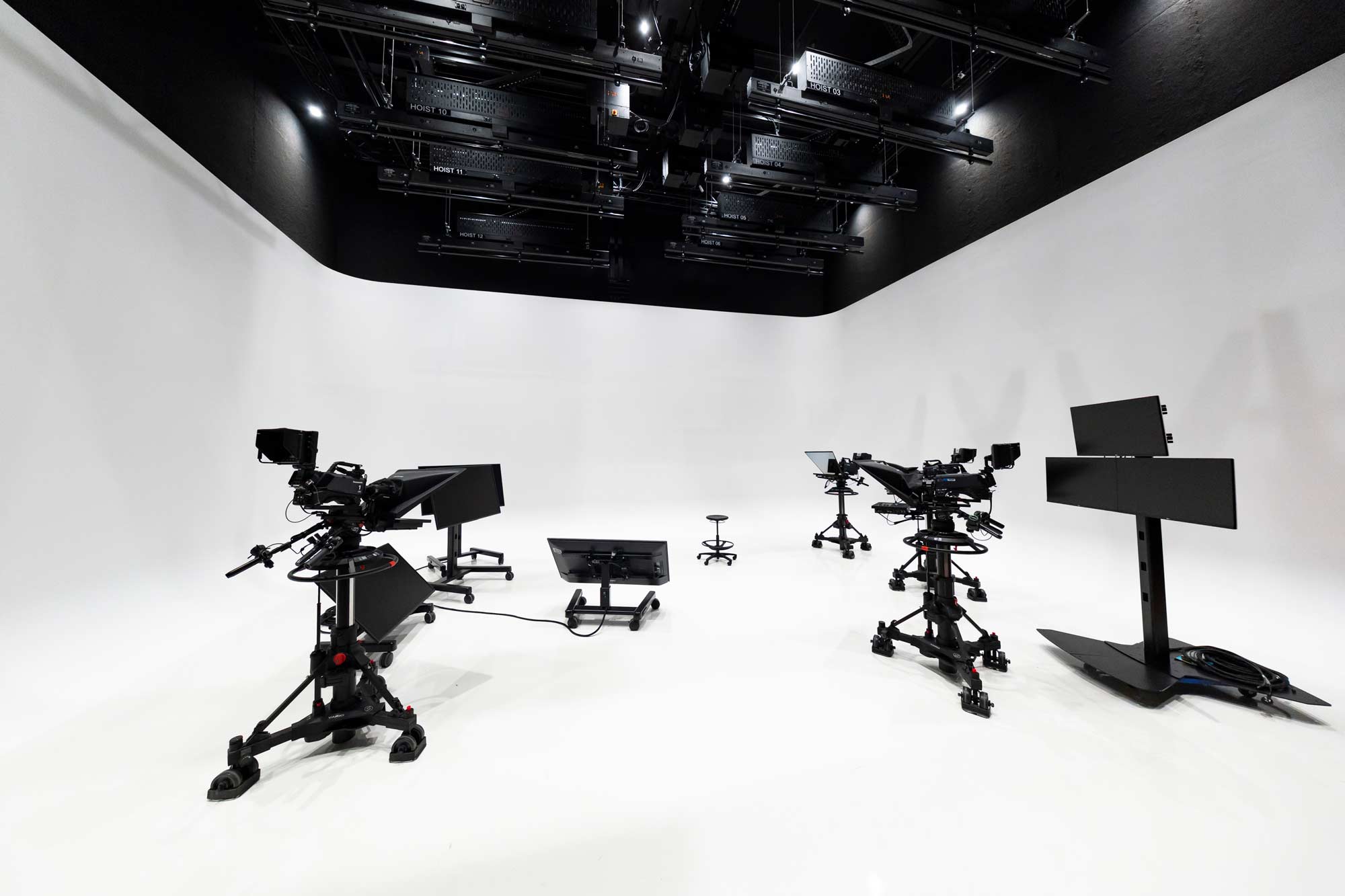 A white room with technical equipment on wheels and ceiling mounted.