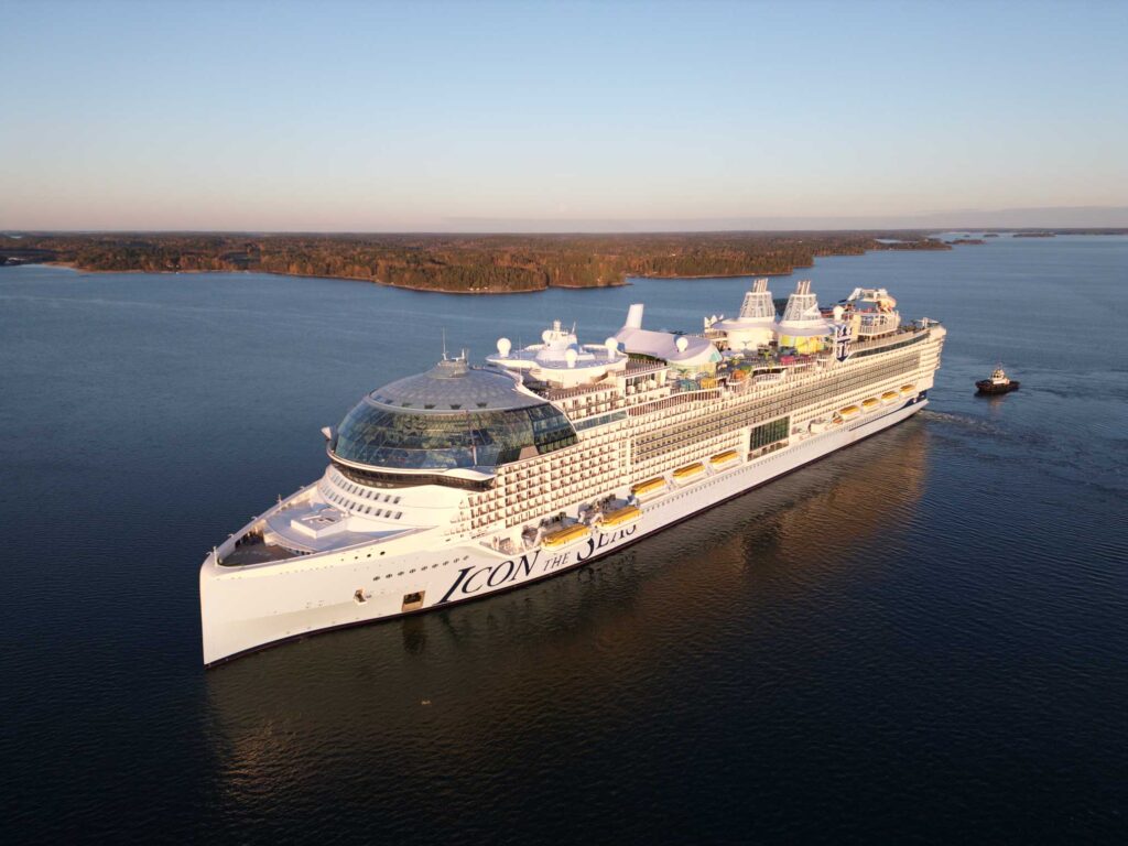 The Icon of the Seas seen from above as it traverses a bay.