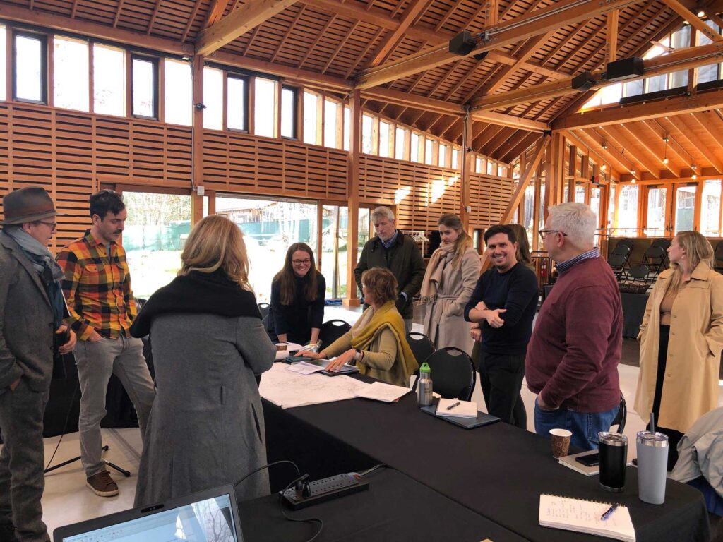 Team members gather around architectural plans.