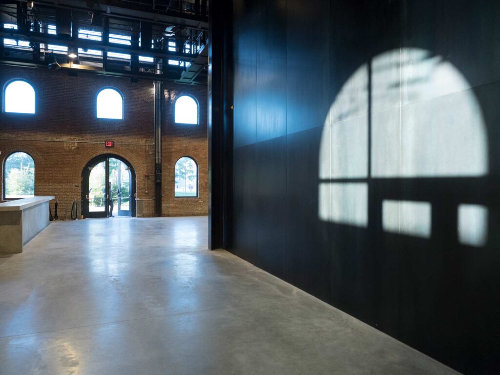 The lobby space with light shining through the arched windows.