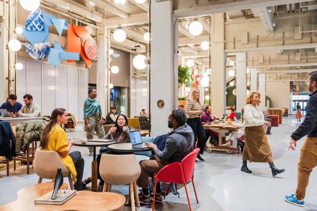 People gather around laptops in a contemporary open plan gathering area.