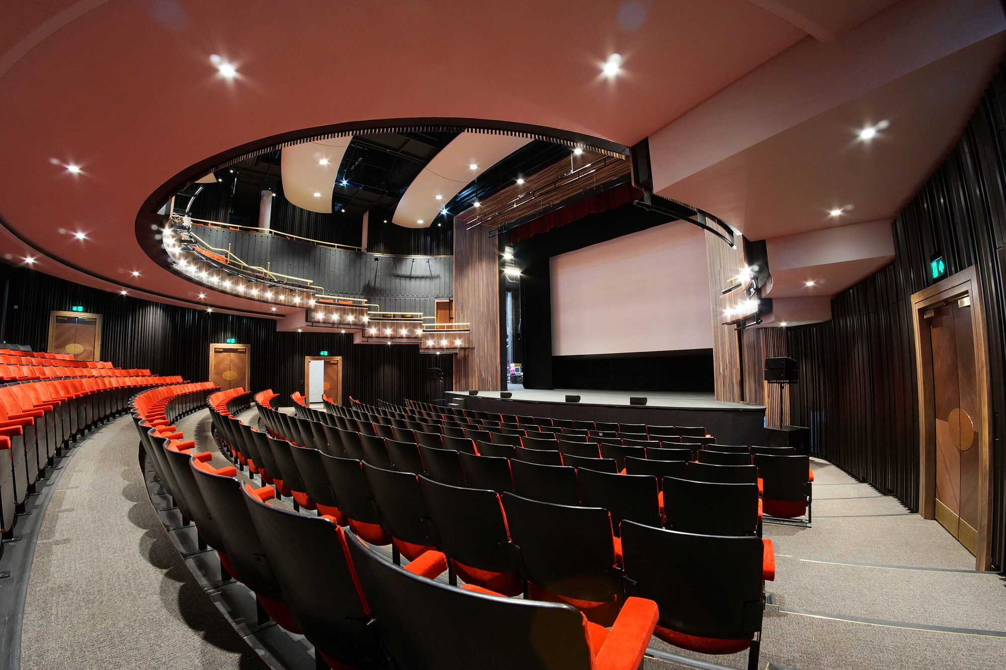View of the stage and semi-circular balcony seen from below at Bloomsbury Theatre.