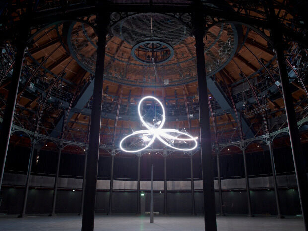 A three lobed light hanging from the ceiling at Camden Roundhouse.