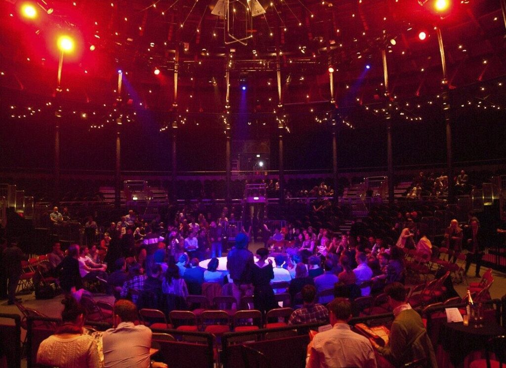 Folding chairs are arranged in a circle on the stage.
