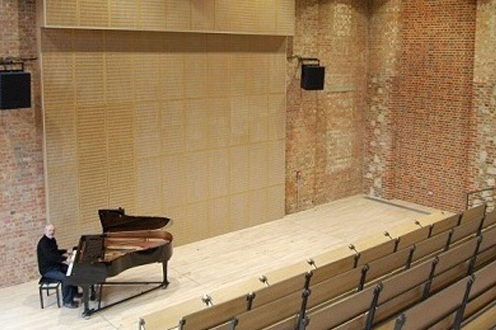 Pianist looking up toward seating area.