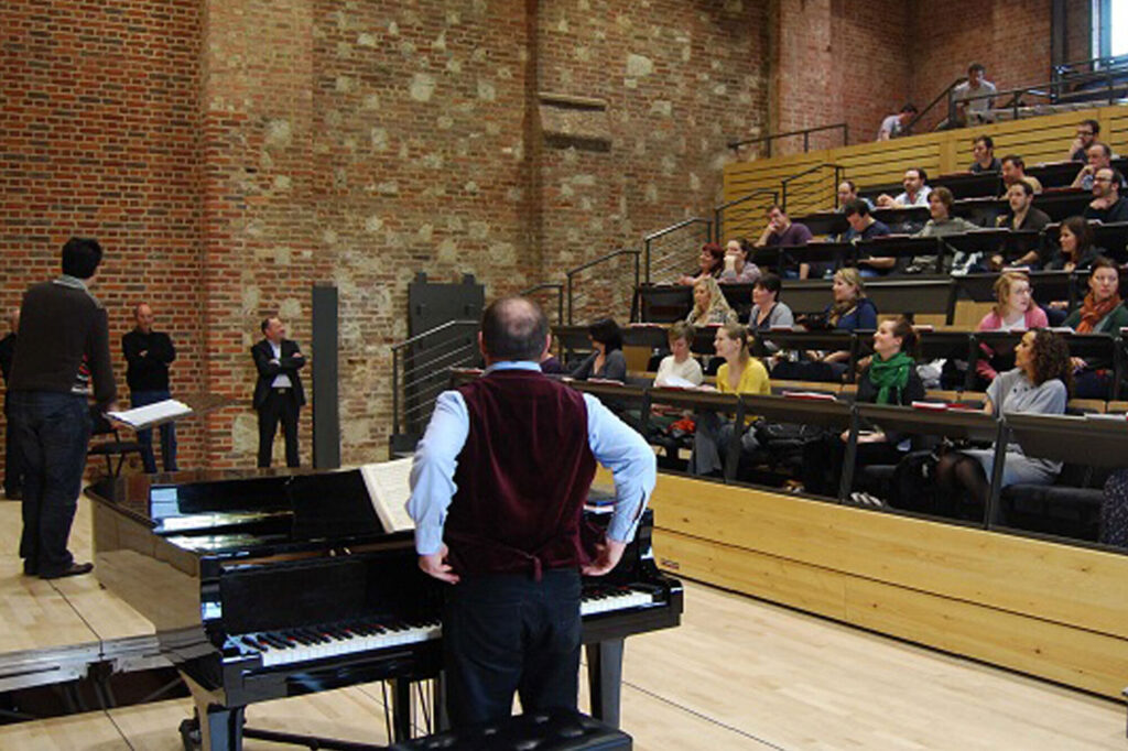 Pianist and elevated section of stage with audience looking on.