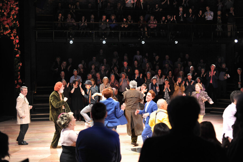 Performers surrounded by clapping audience.