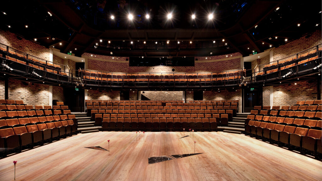 Wooden stage in brick-walled theatre.