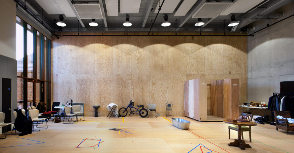 A plywood room with costumes and props.