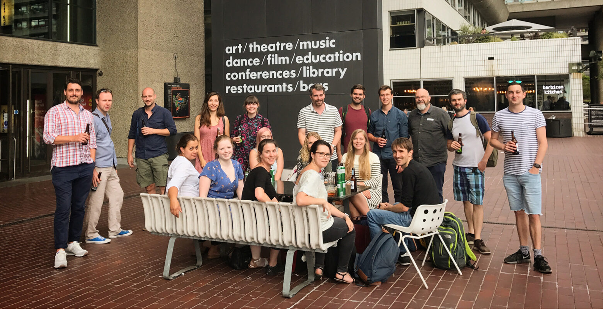 Team members gather in a plaza outside a theatre.