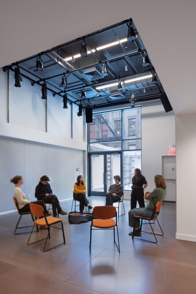 People sit in a circle under lighting equipment. Images by John Bartelstone Photography
