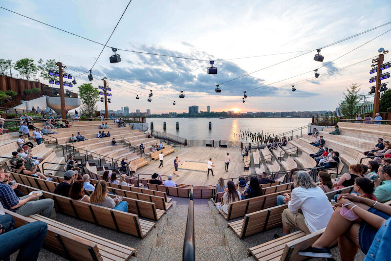 The outdoor seating area looking across the Hudson River to New Jersey. Speakers are strung overhead. © Timothy Schenck