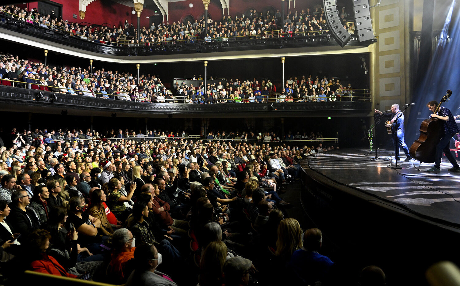 Musicians on stage before a packed audience.
