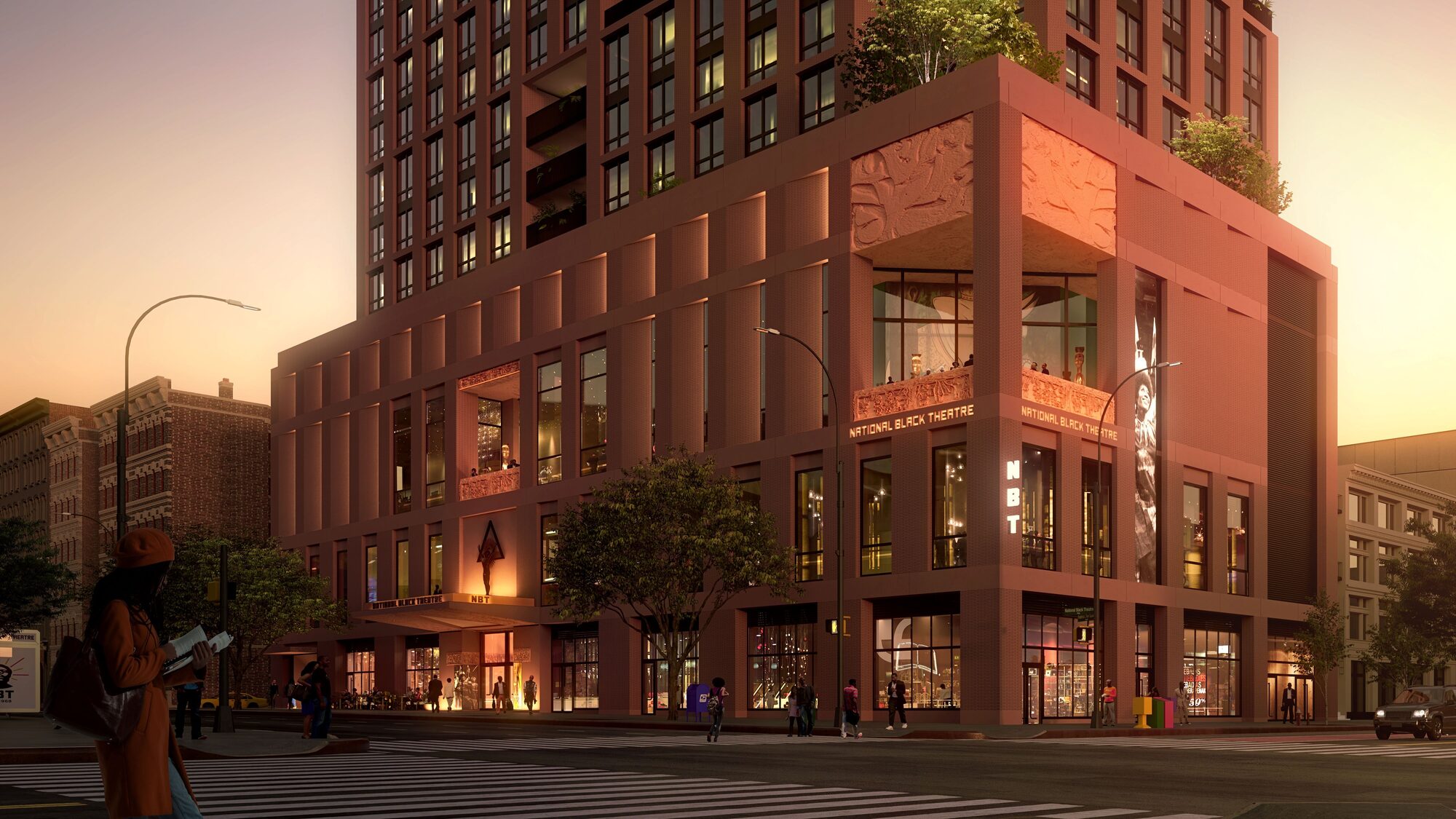 A brick red building at sunset. The corner of the building is engraved with large decorative reliefs.