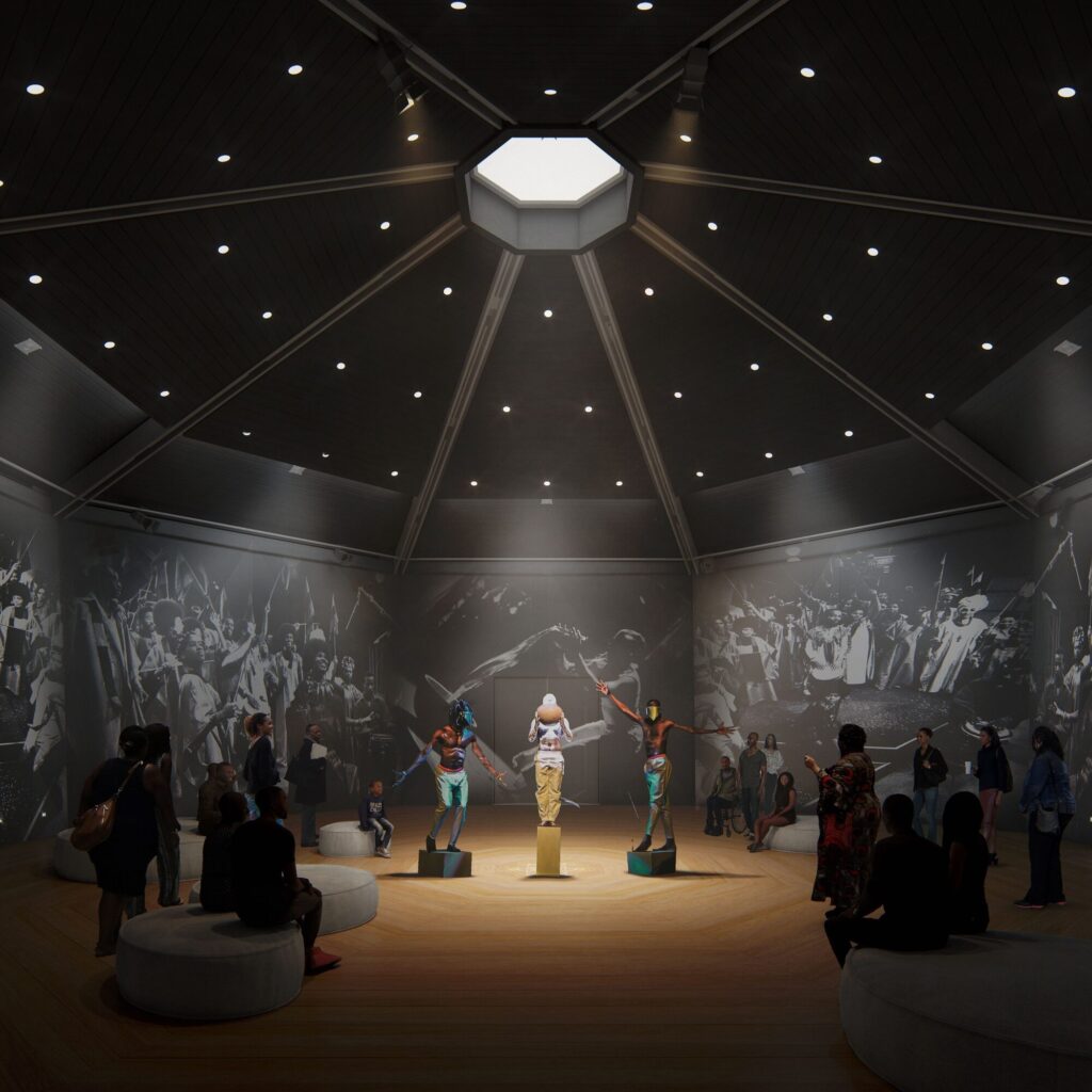A seven sided aperture illuminates a round, many-sided room. Black and white photographs cover the walls and figures stand on low plinths in the middle of the room while visitors look on.