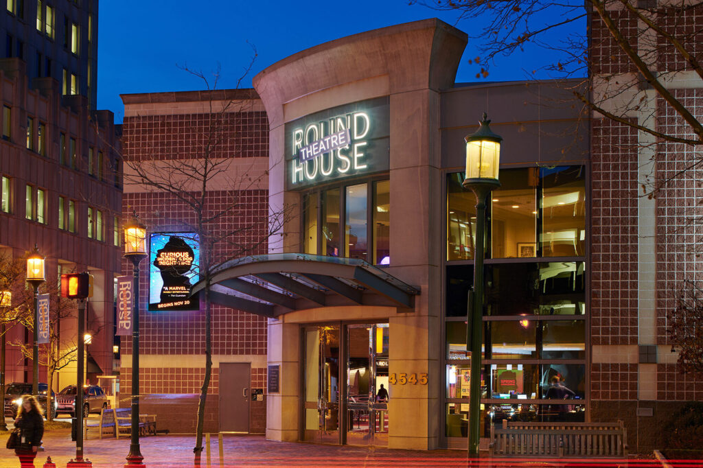 Exterior of Round House Theatre at night in an urban area.