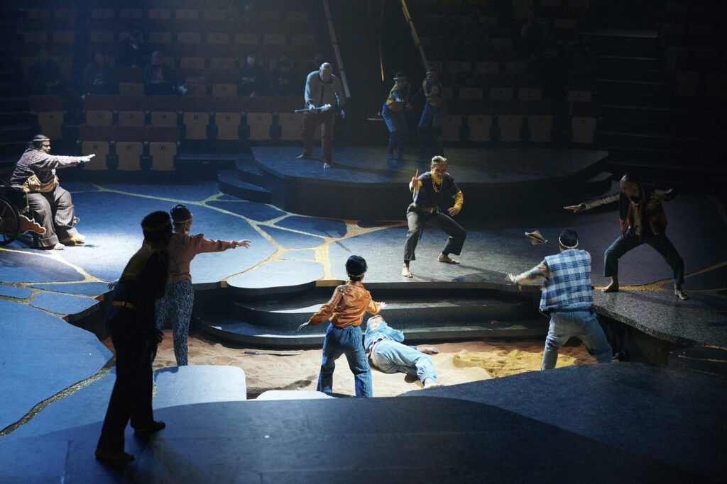Performers on stage point at each other.