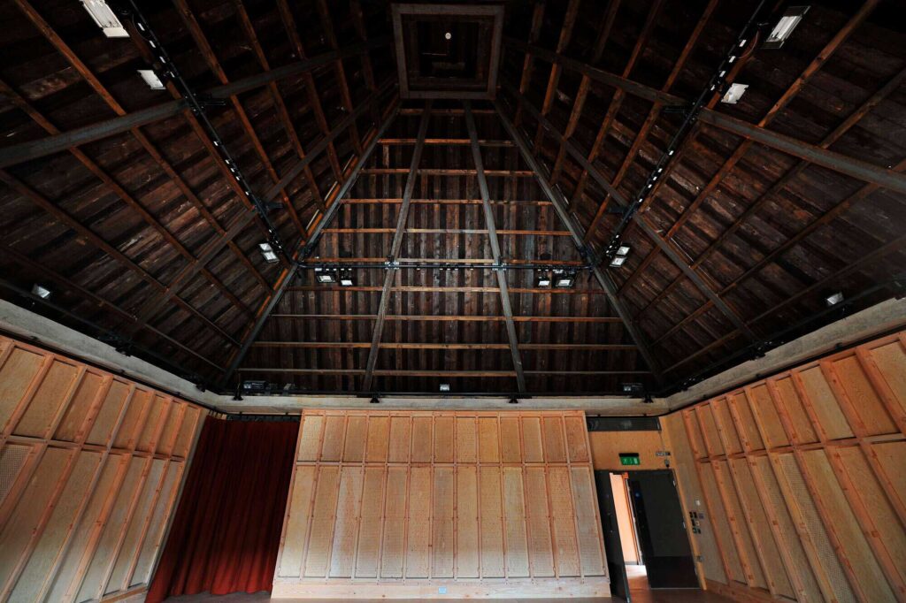A look up at the wooden roof with AV equipment running around the perimeter.