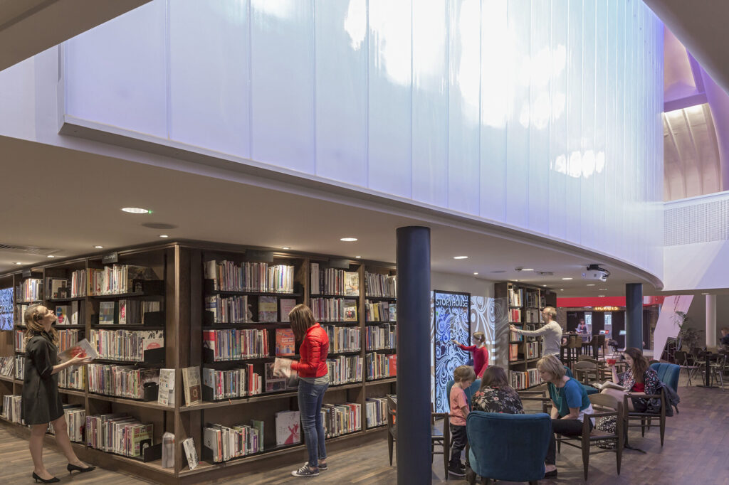 People browse books on the first floor of the Storyhouse library space. Photo by Peter Cook.