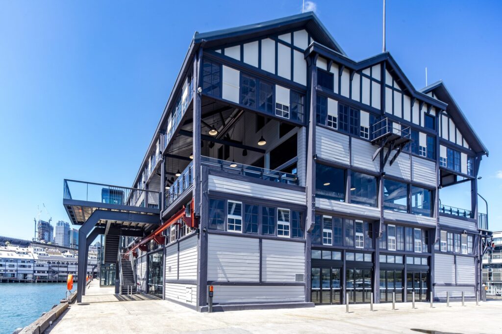 Exterior view of the wharf building with multiple levels of glass windows and iron balconies.