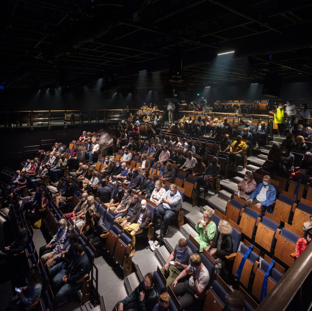 Audience in a raised seating area.