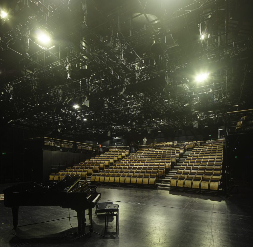 Raised seating area in blackbox theatre with elaborate catwalk.