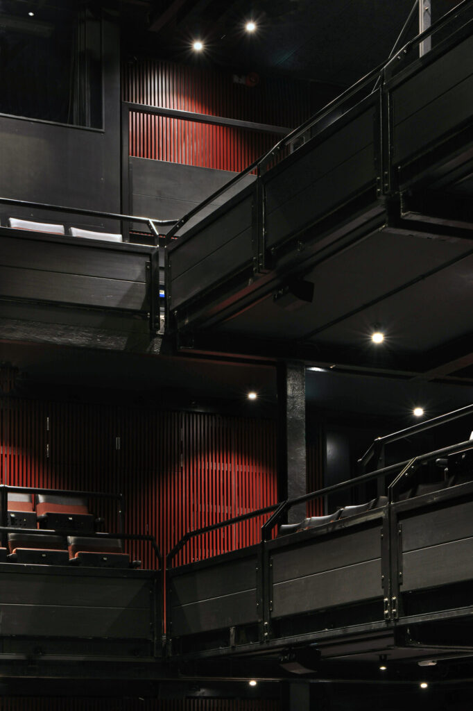 A view of first and second balcony. The wall is finished with red slats.