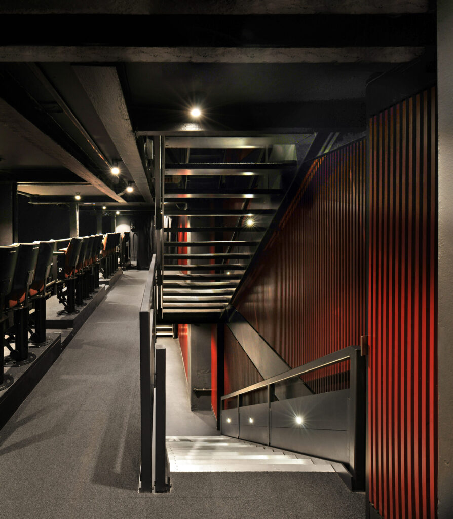 A view of stairs descending and ascending behind a row of seating.