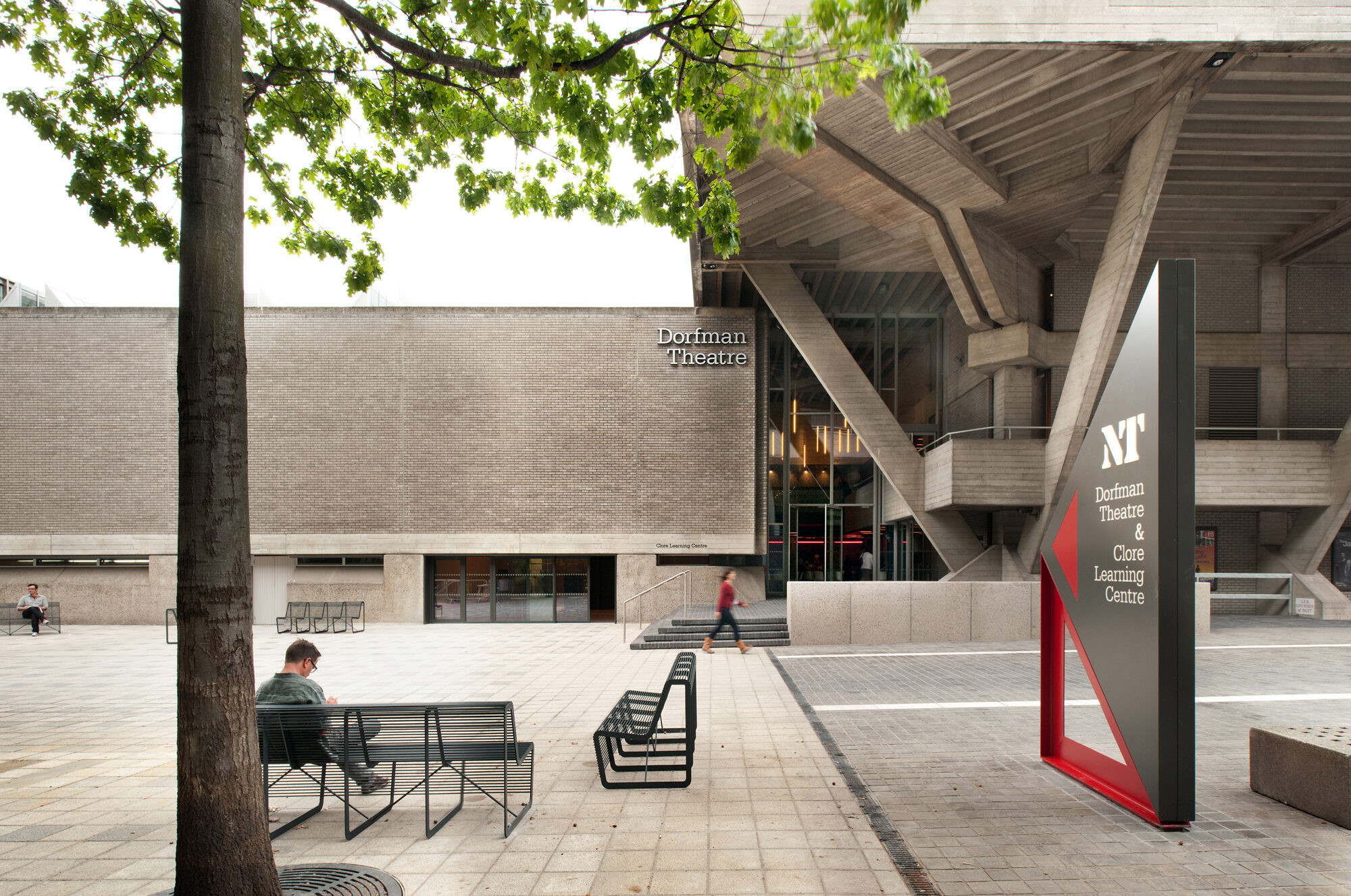 A plaza with exterior signage indicating the location of the Dorfman Theatre.