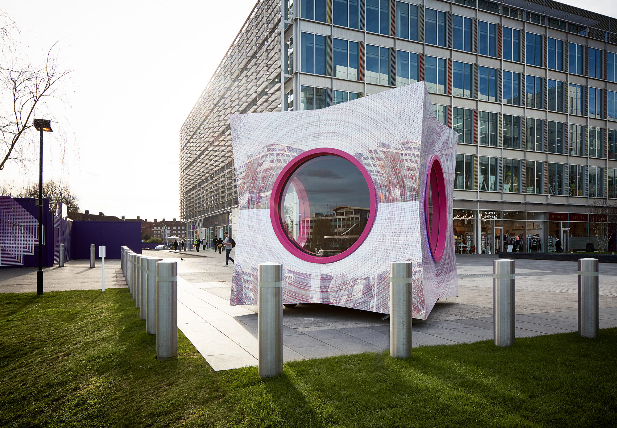 Exterior of the Pod sitting in a plaza by day.