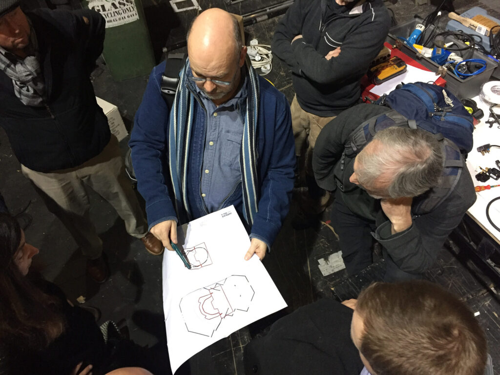 Team members gather around and look at a simple floor plan.