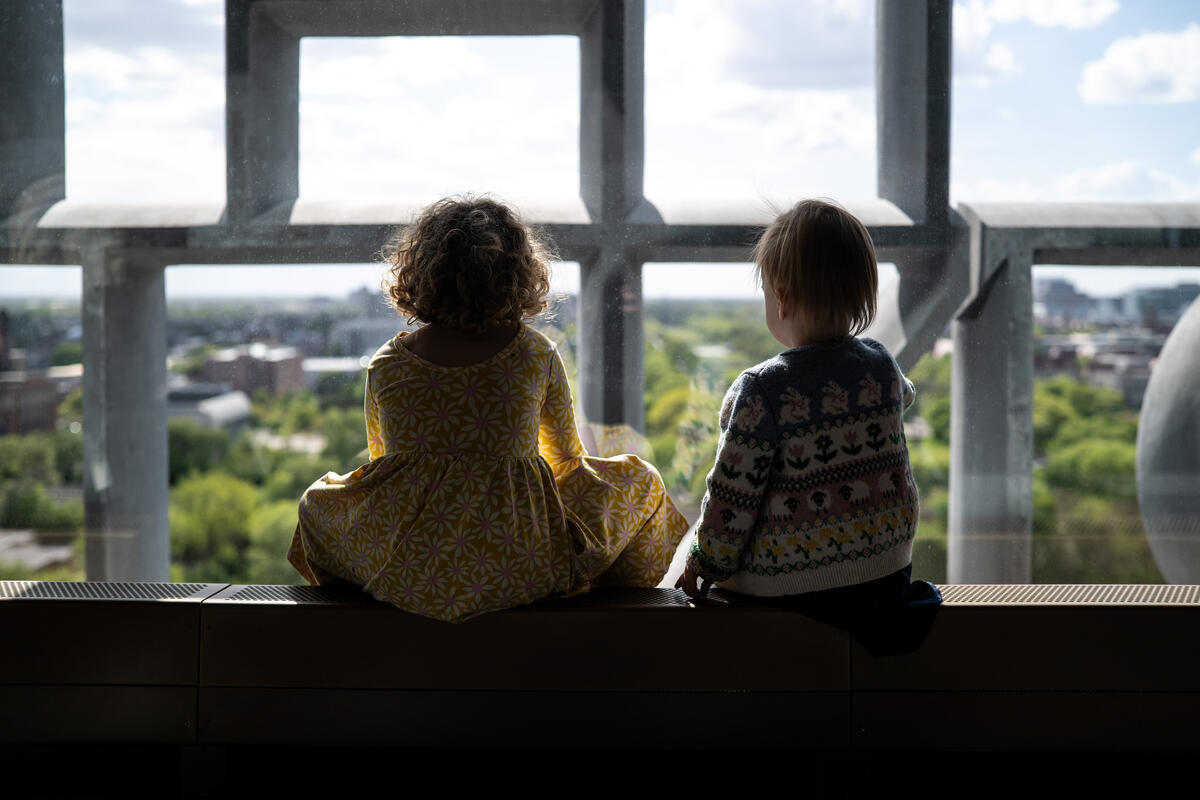 Two children look out the window.