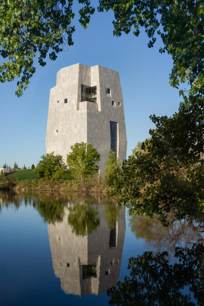 Exterior of the Obama Presidential Center reflected in water.