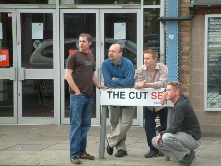 The original Charcoalblue team members pose by a sign.