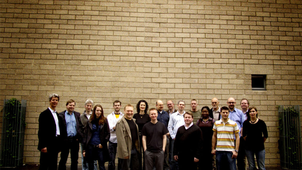 A group of Charcoalblue team members against a brick wall.